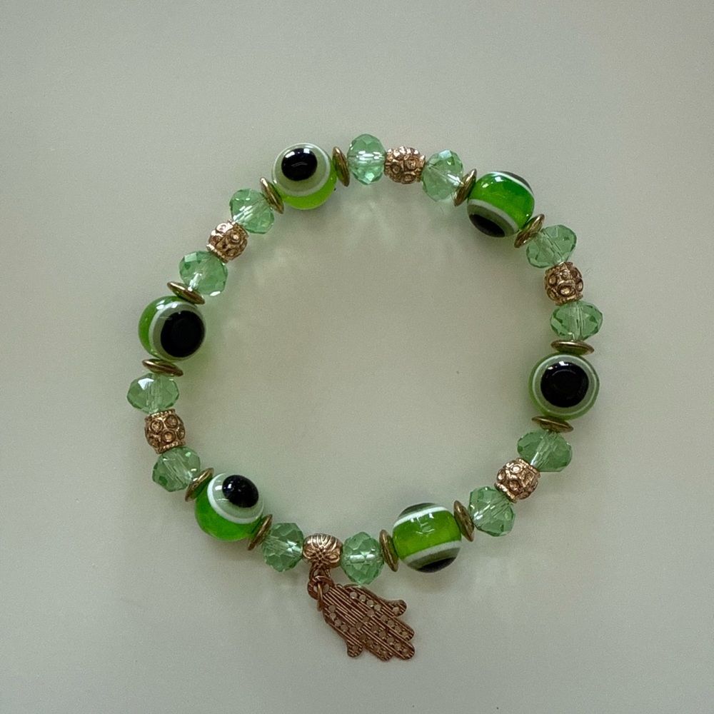 Green and gold tone evil eye beaded stretch bracelet with gold hamsa charm